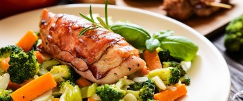 Pollo envuelto en tocino acompañado de verduras al vapor